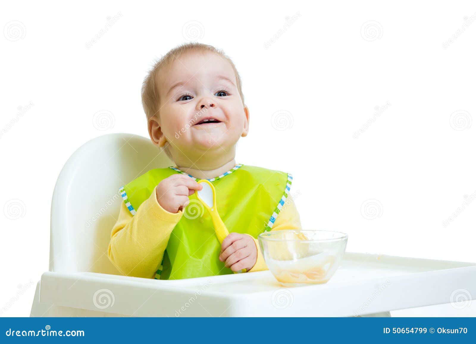 Gelukkig babyjong geitje die op voedsel met lepel wachten. Gelukkig babyjong geitje die op voedsel met lepel bij lijst wachten