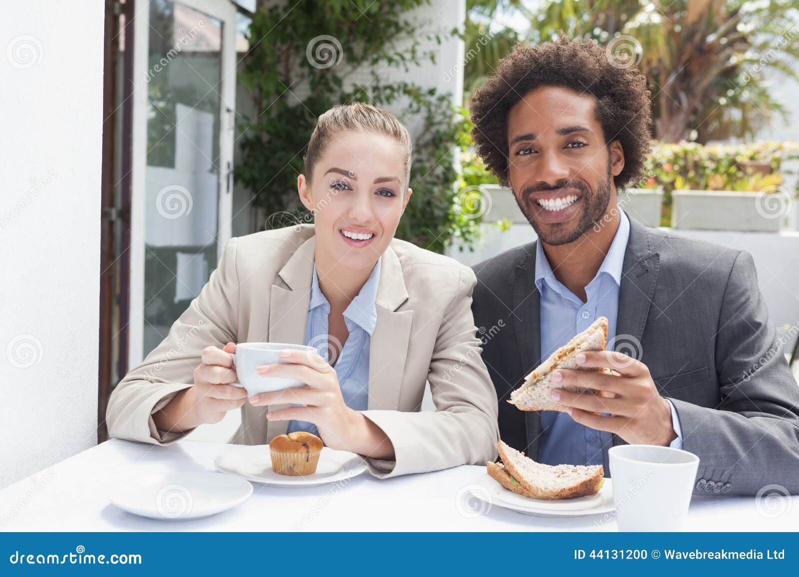 Gelukkige bedrijfsmensen op hun lunch buiten bij de koffiewinkel