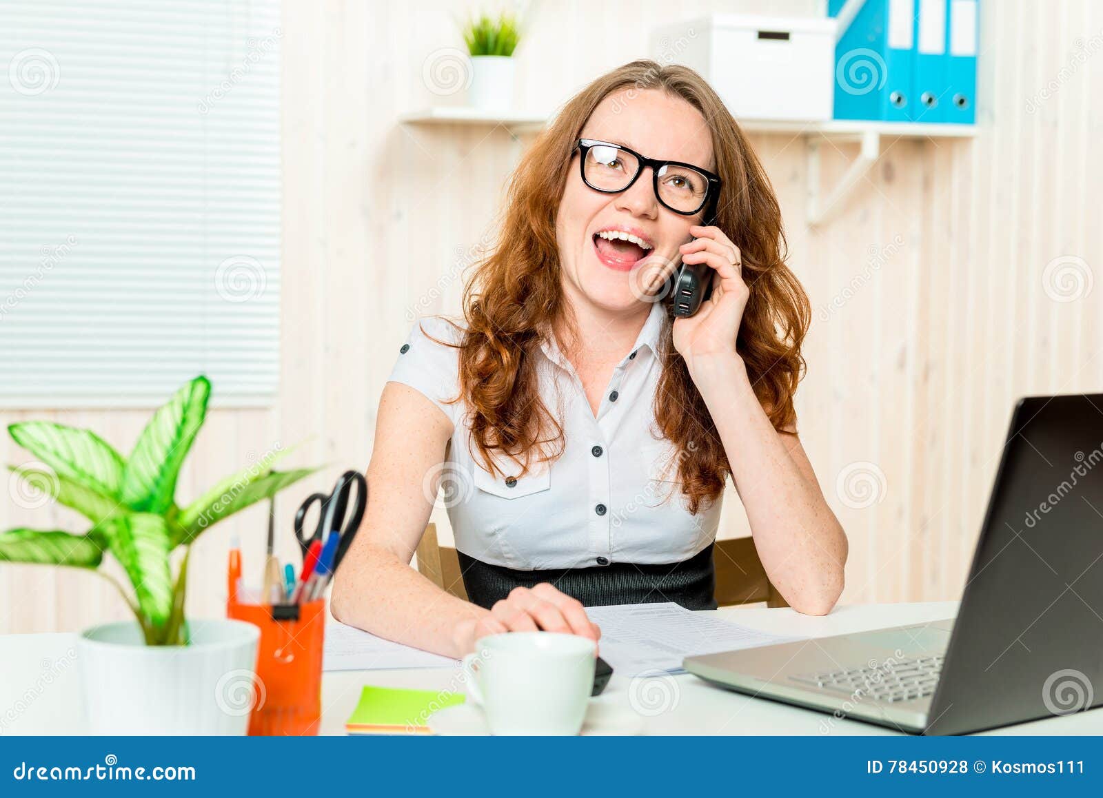 Gelukkige directeur die van vrouw op de telefoon spreken. Gelukkige directeur die van vrouw op de telefoon in het bureau spreken