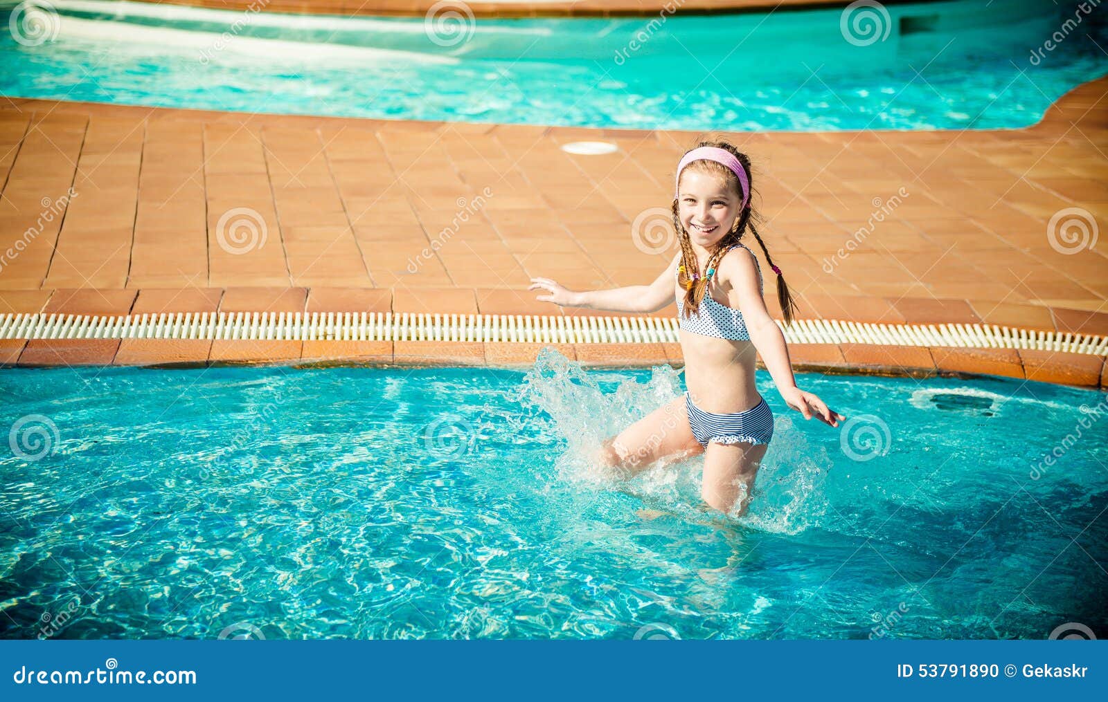 Gelukkige gir in de pool. Weinig gelukkig meisje zwemt in de pool