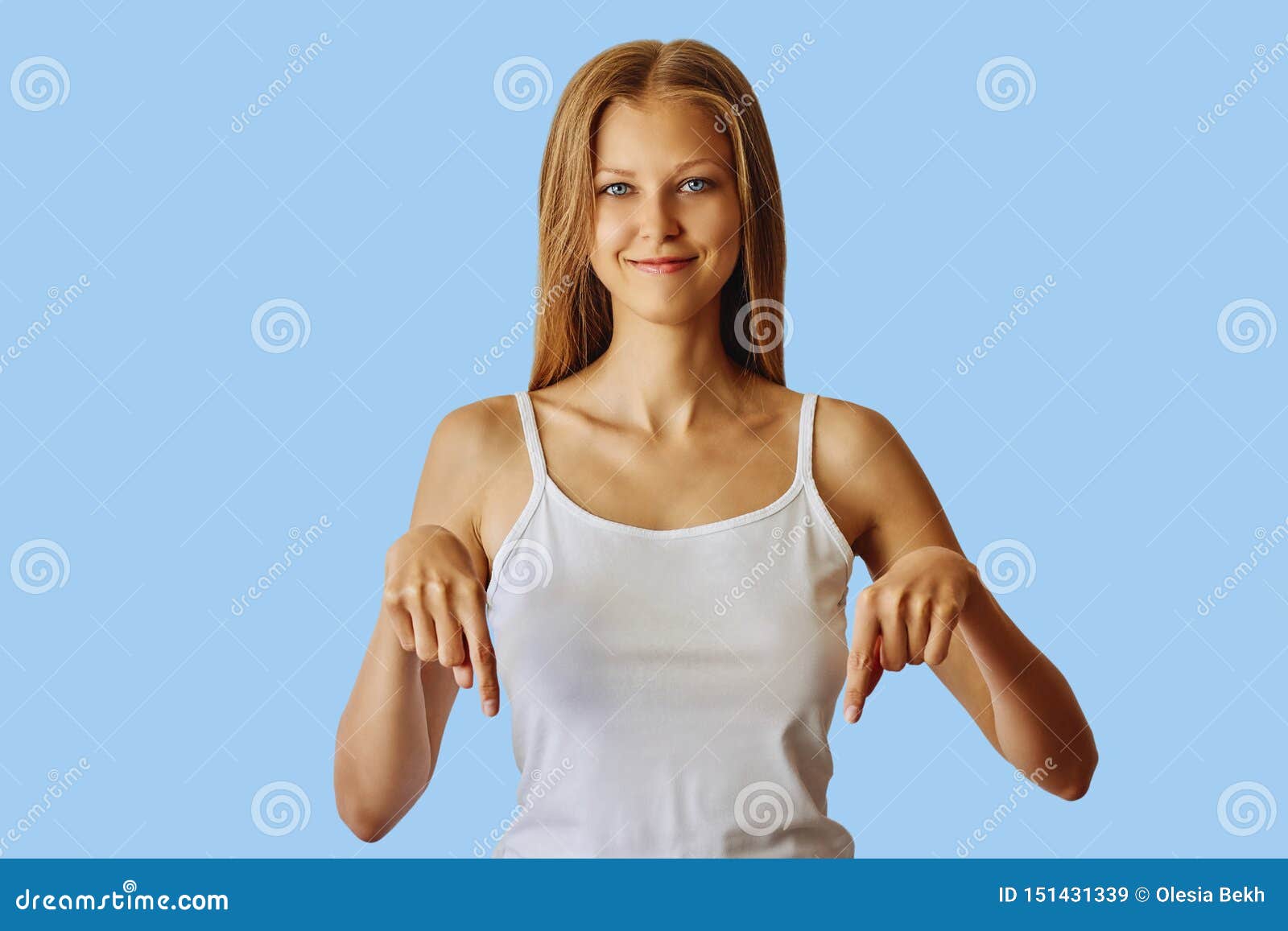 Gelukkige glimlachende vrouw die neer met wijsvingers richten. Gelukkige glimlachende vrouw die die neer met wijsvingers richten, over blauwe achtergrond worden geïsoleerd