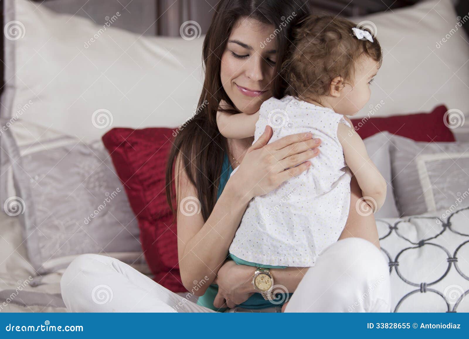 Gelukkige moeder die haar baby koesteren. Leuke jonge moeder die haar babymeisje koesteren