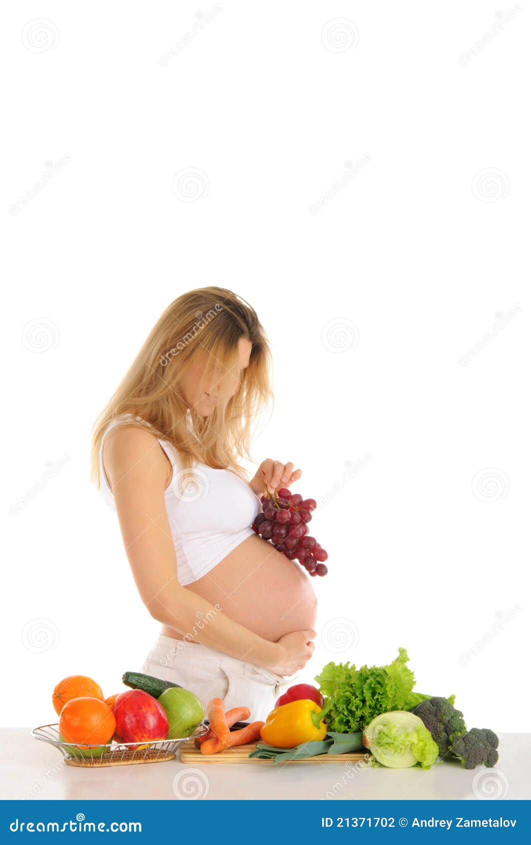 Gelukkige zwangere vrouw met vruchten en groenten die op wit worden geïsoleerd&amp;