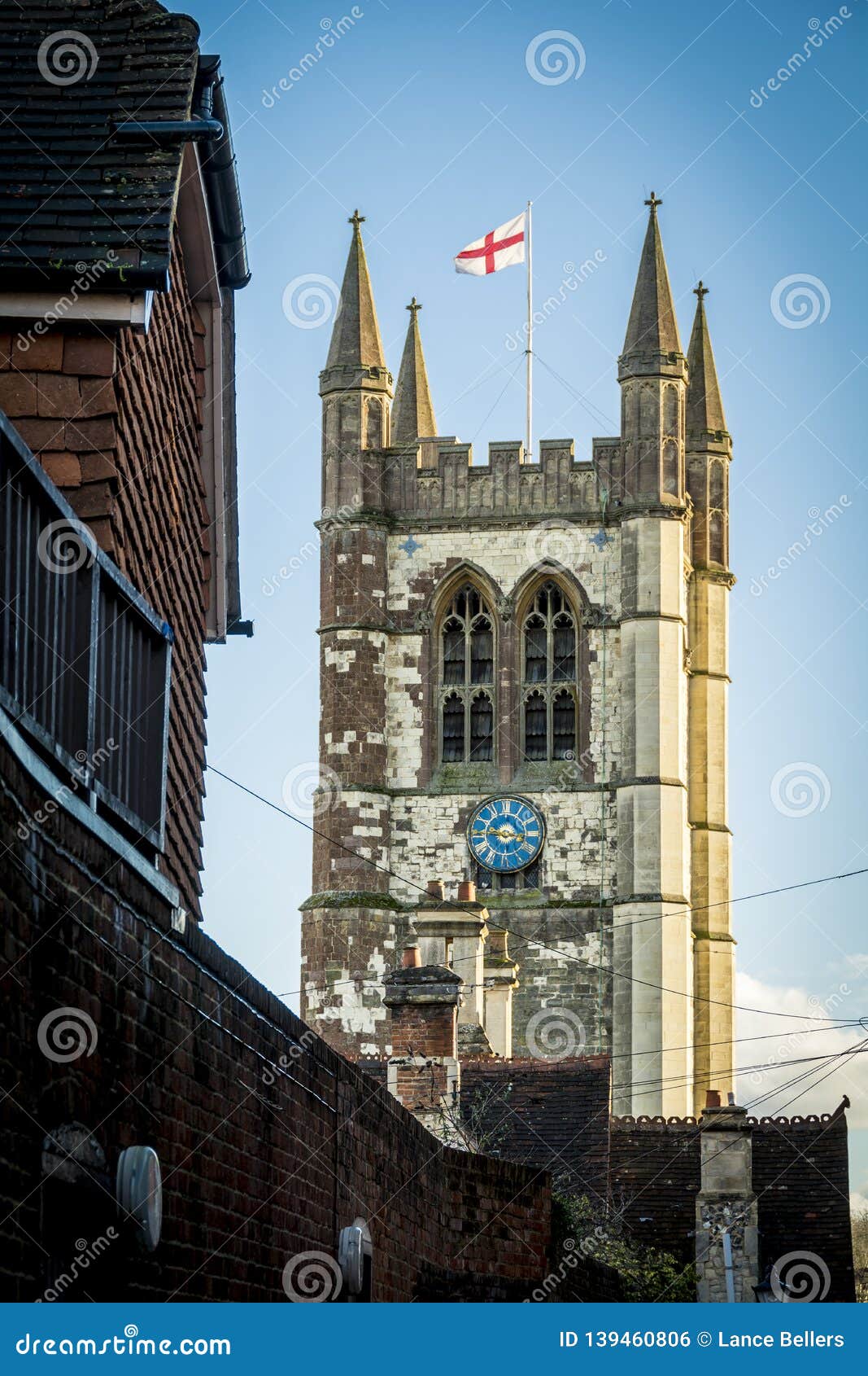 Gemeindekirche in Farnham in Surrey mit England-Flagge. St. Andrews Church, der oben von der typischen Straße in der Surrey-Stadt schaut