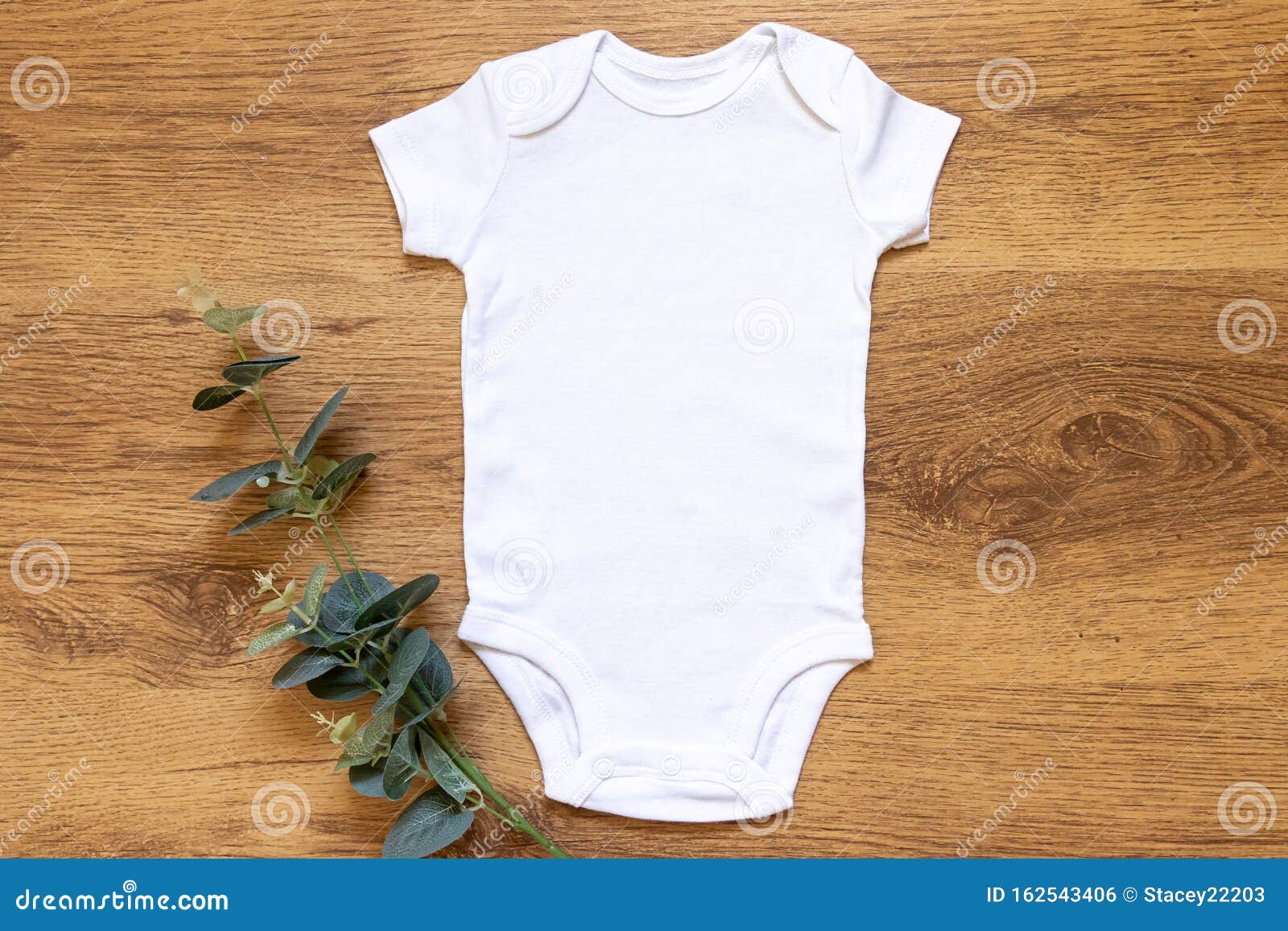 gender neutral blank white babygrow on a wam wooden background