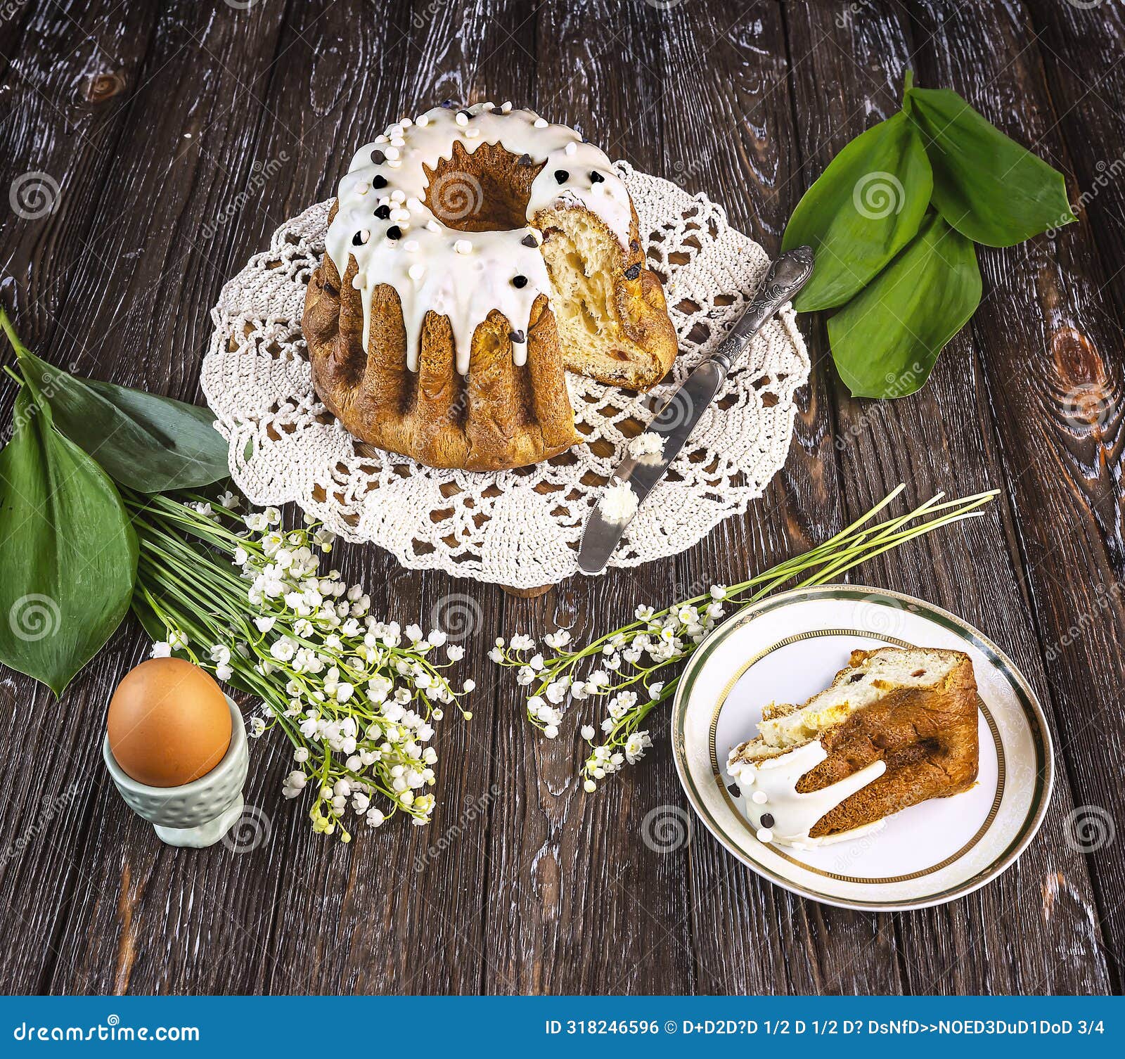 easter cake on a wooden tray, a bouquet of fragrant lily of the valley flowers, an easter egg