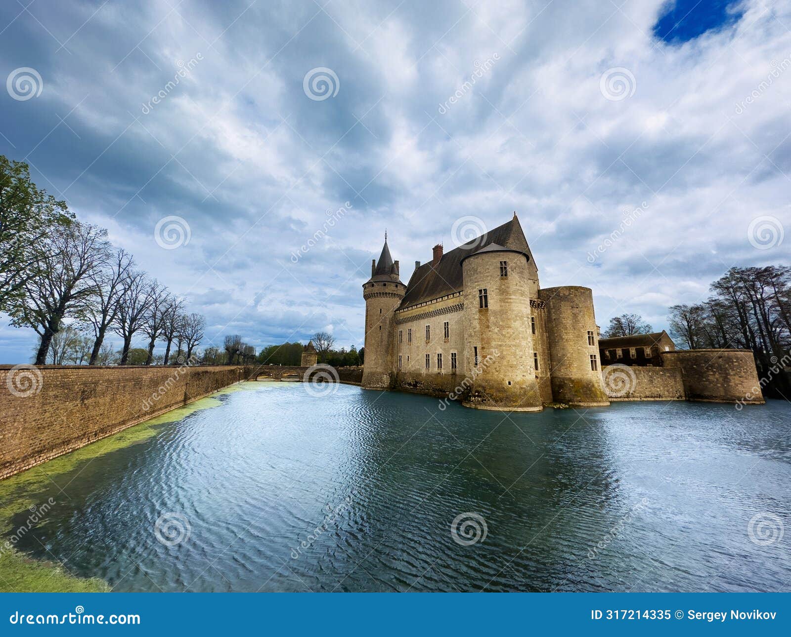 majestic castle sully sur loire surrounded by water under clouds