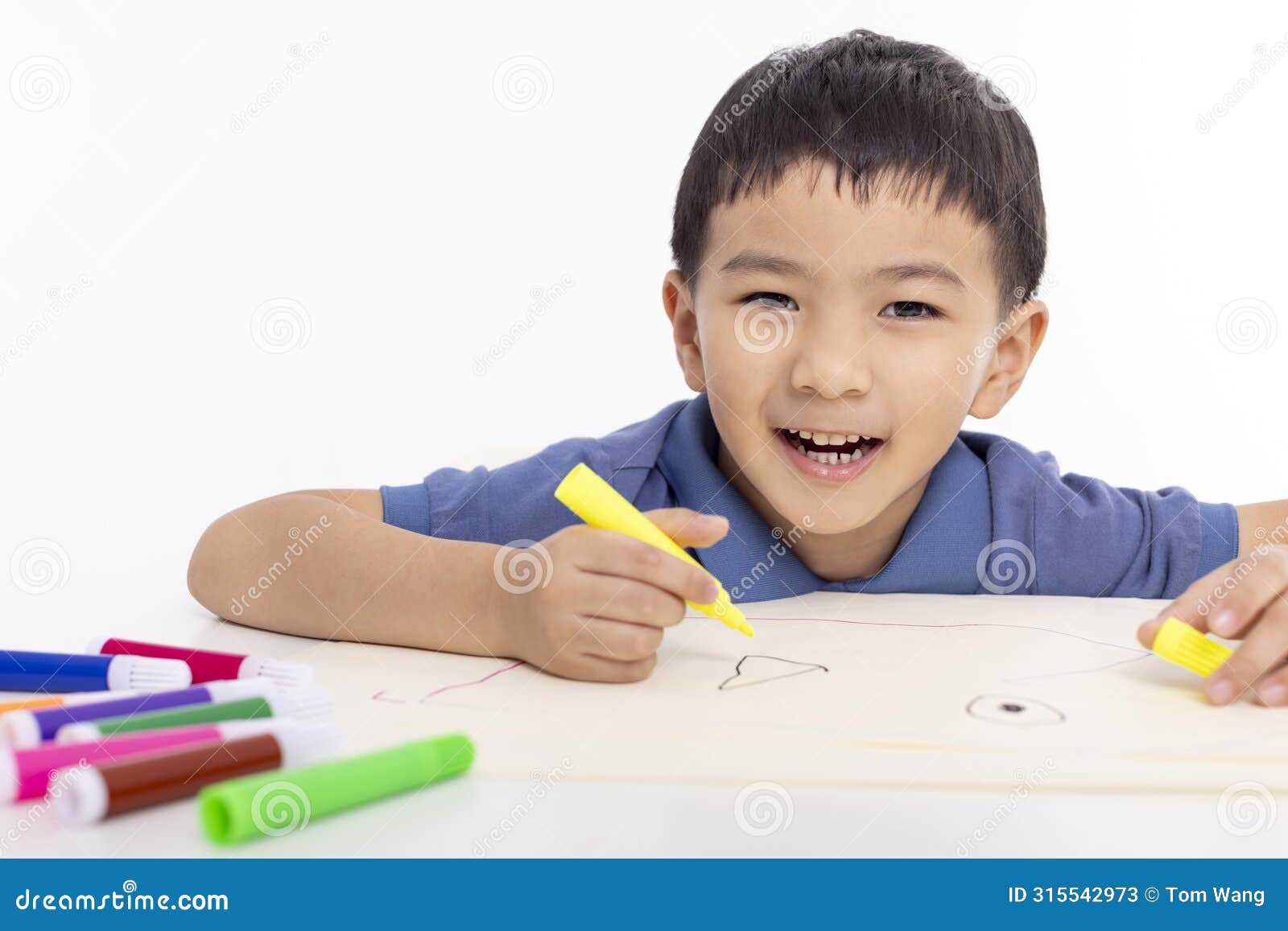 smiling asian child schoolboy painting and drawing at home