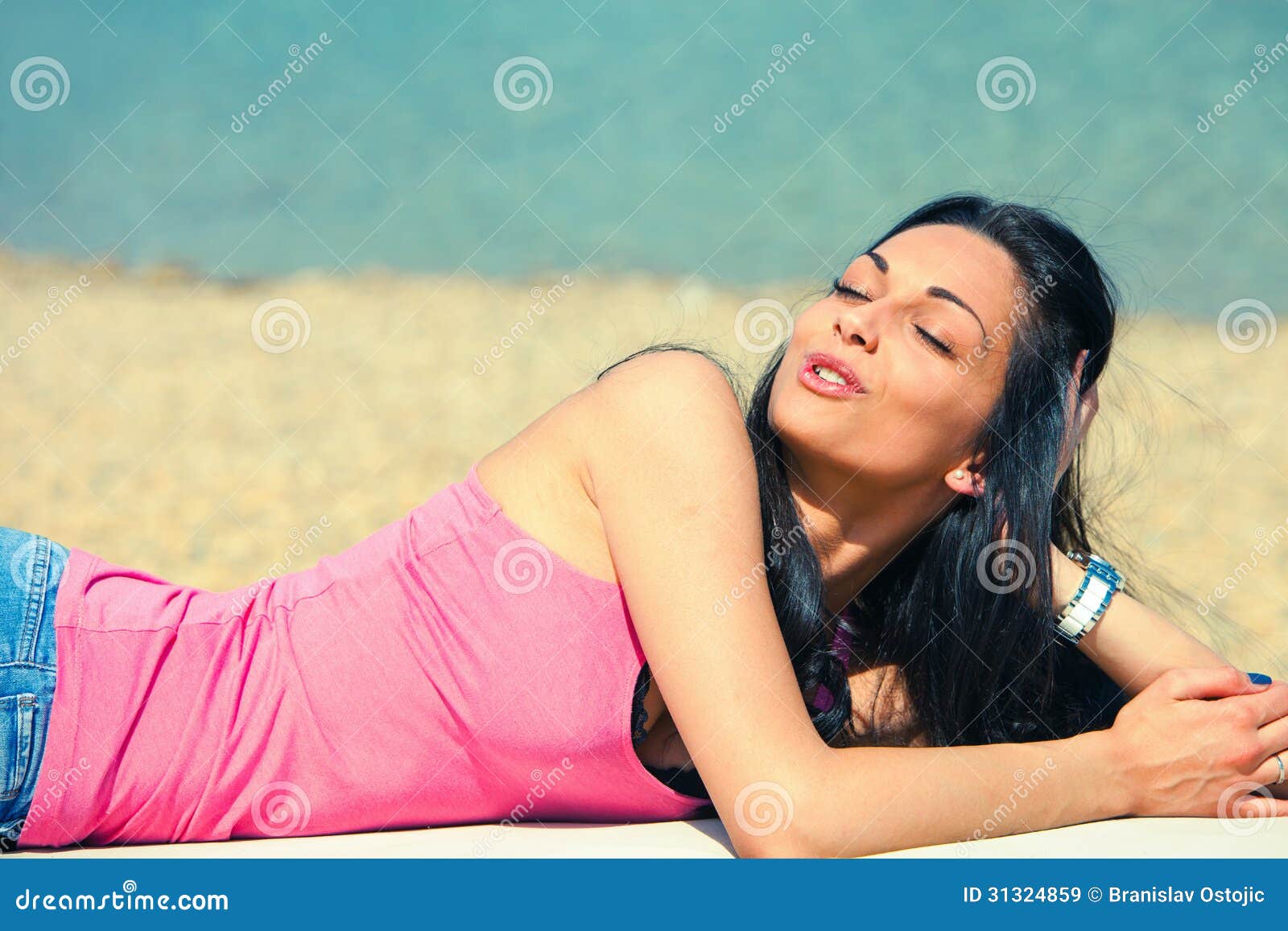 De jonge vrouw geniet van in zon op strand, de zomerdag