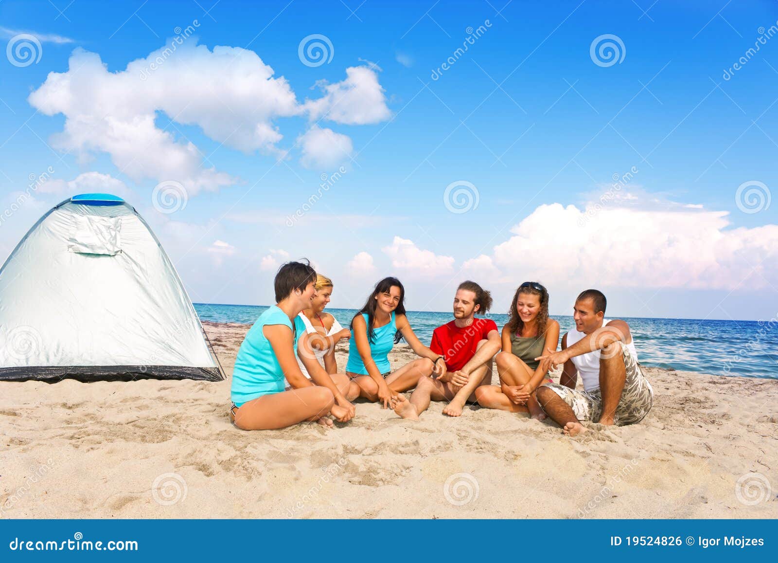 Gente joven que acampa en la playa. Gente joven del grupo que acampa junto en la playa