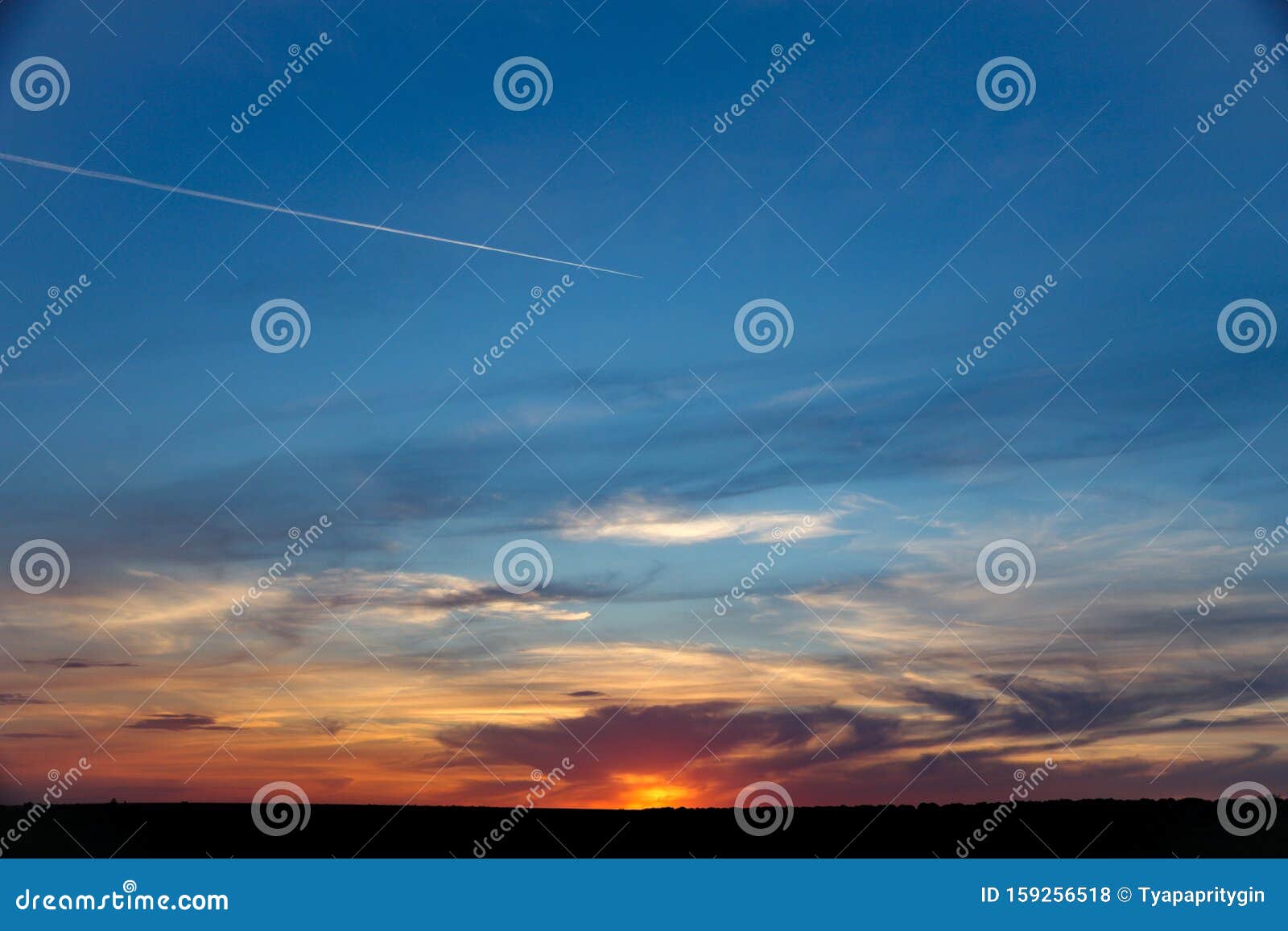 gentle sky at sunset with contrails from airplane