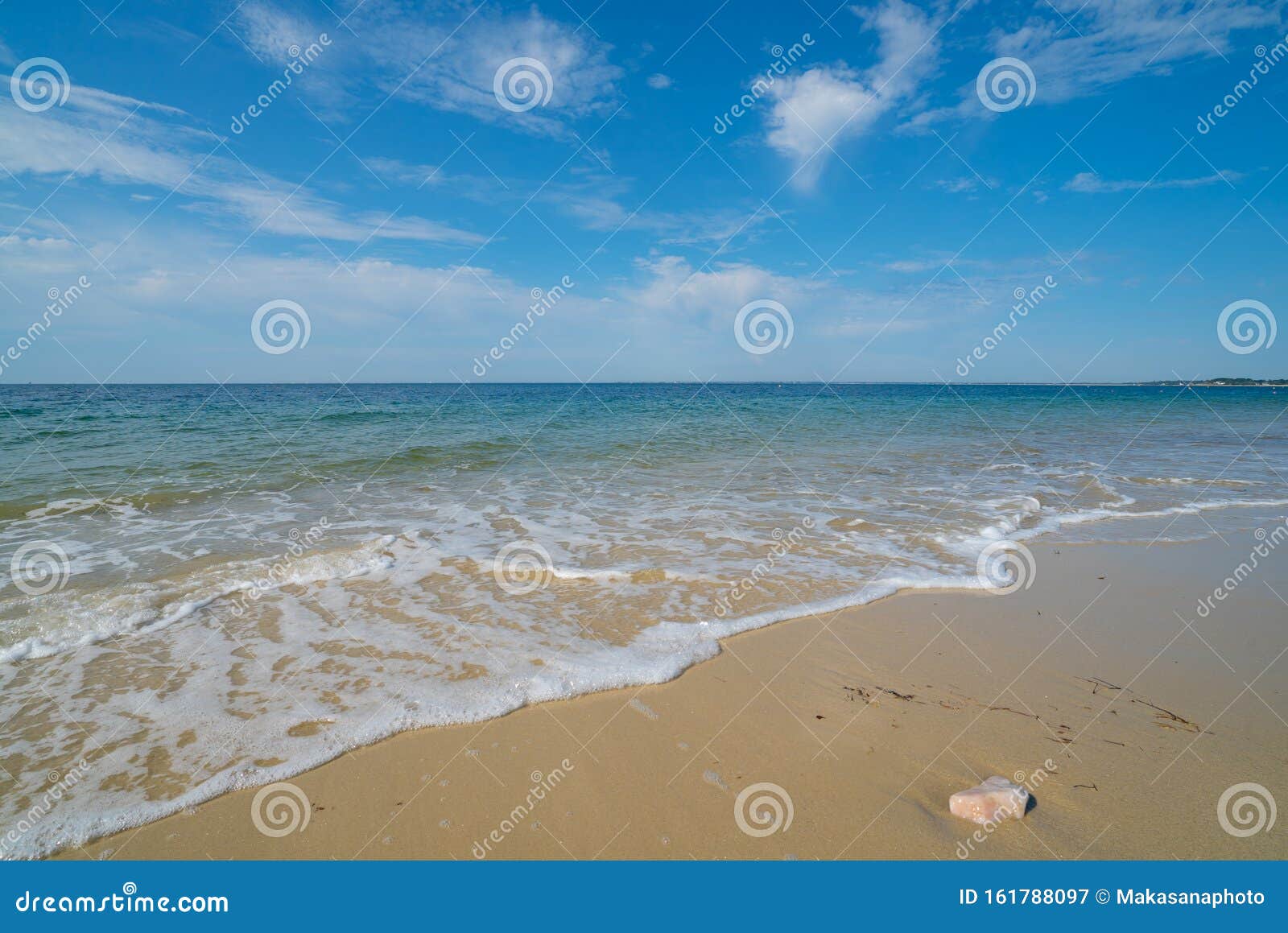 gentle waves on an empty sandy beach with a calm ocean