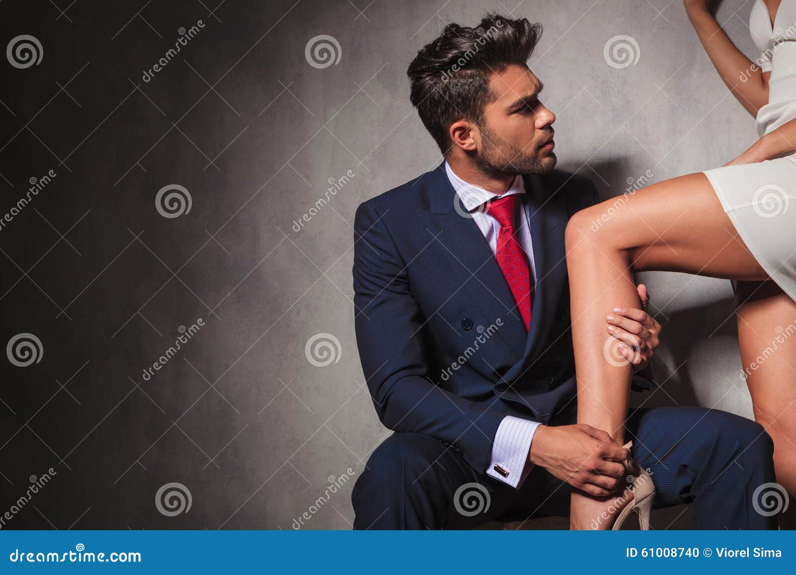 gentleman is helping his woman to get her shoes on