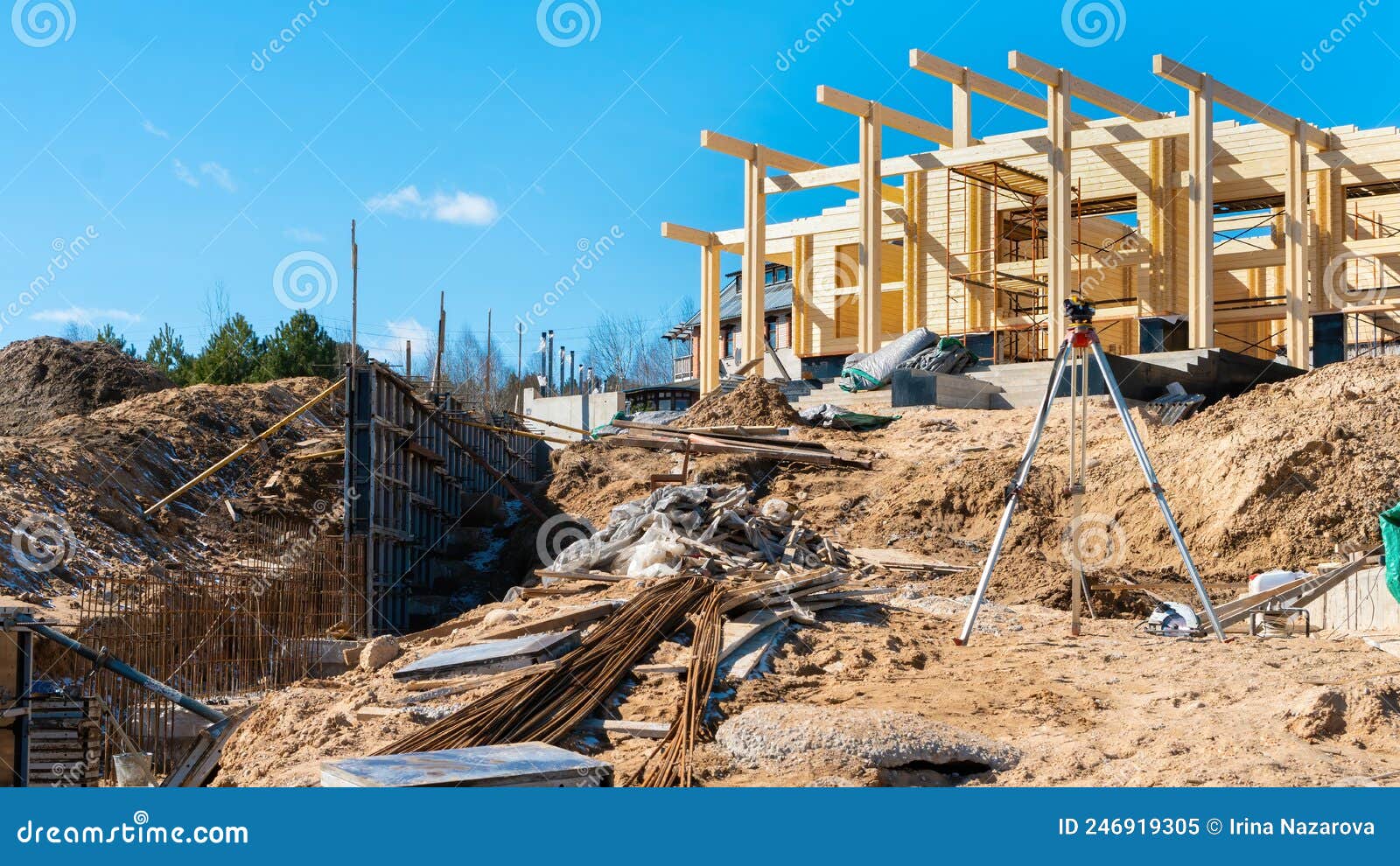 geodetic work using an automatic level instrument at the construction site of a wooden house made of glulam or laminating stock.