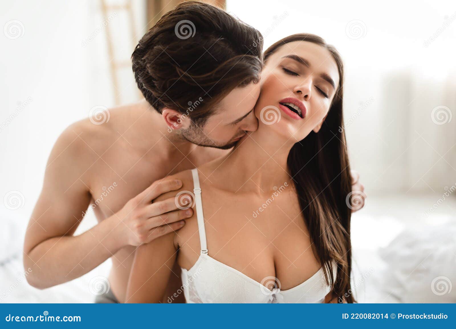 Gepassioneerde Man Die Vrouwen Zoent Terwijl Ze Seks Hebben in Slaapkamer Binnenshuis Stock Foto afbeelding