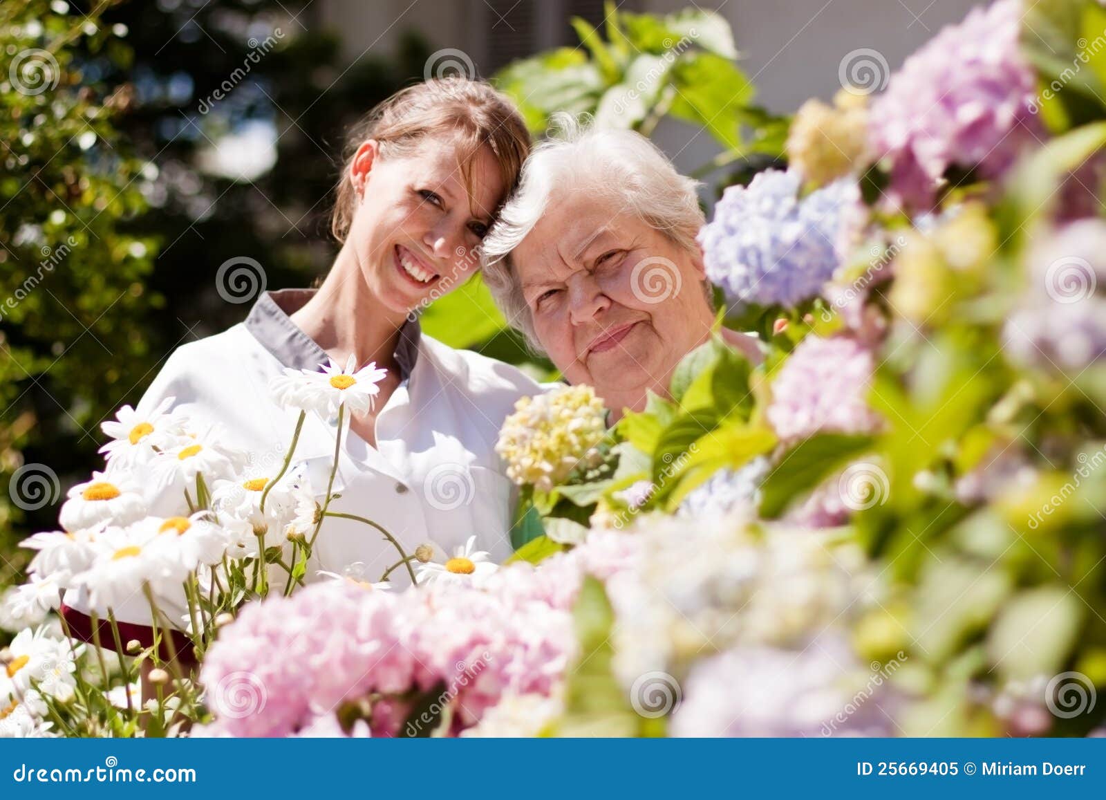 geriatric nurse with elderly woman in the garden