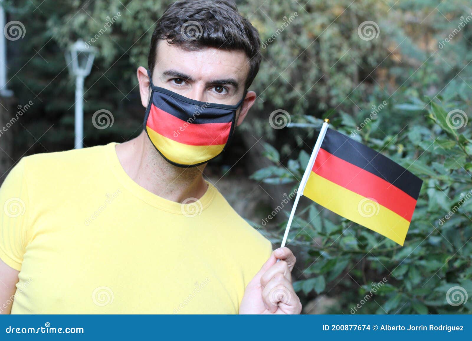 German Man Wearing Protective Mask with National Flag Stock Photo
