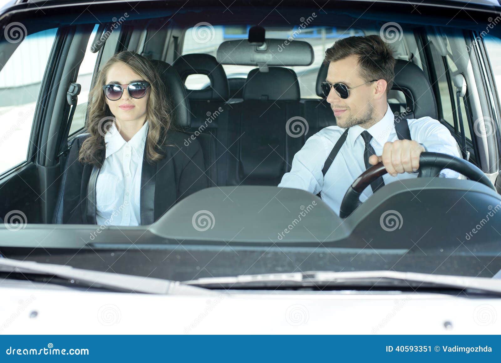 Geschäftsleute im Auto. Geschäftsmann und Geschäftsfrauen, die in das Auto reisen
