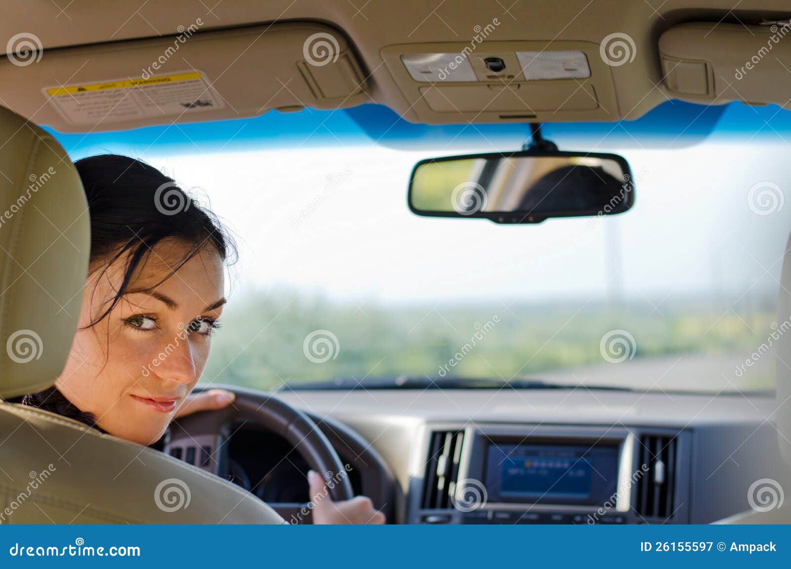 Gestionnaire de femme examinant le siège arrière. Gestionnaire de femme examinant au-dessus du dos du siège de gestionnaires l'arrière du véhicule cassant sa concentration sur la route