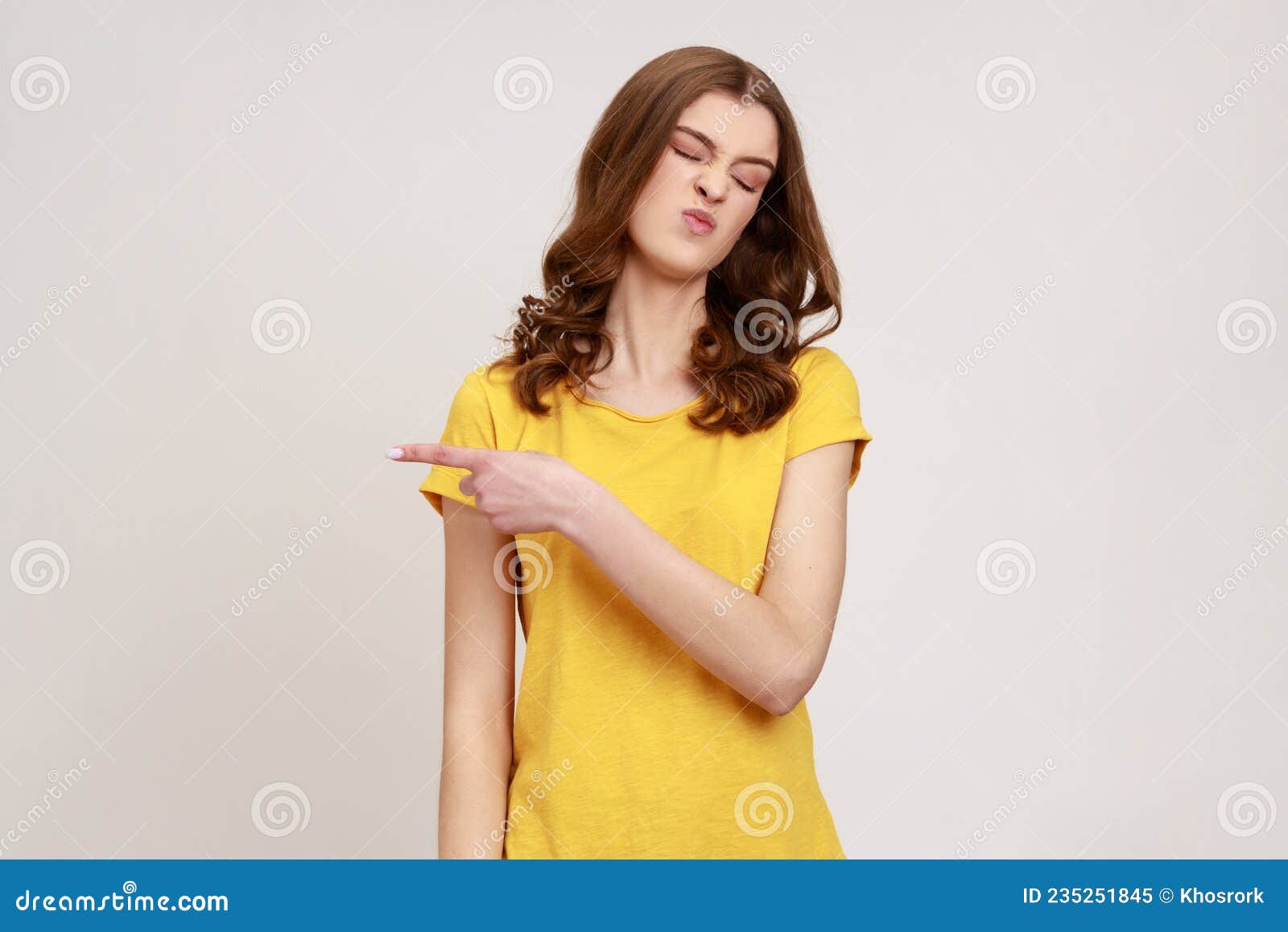 get out. portrait of upset vexed woman of young age with wavy hair showing exit, demanding to leave