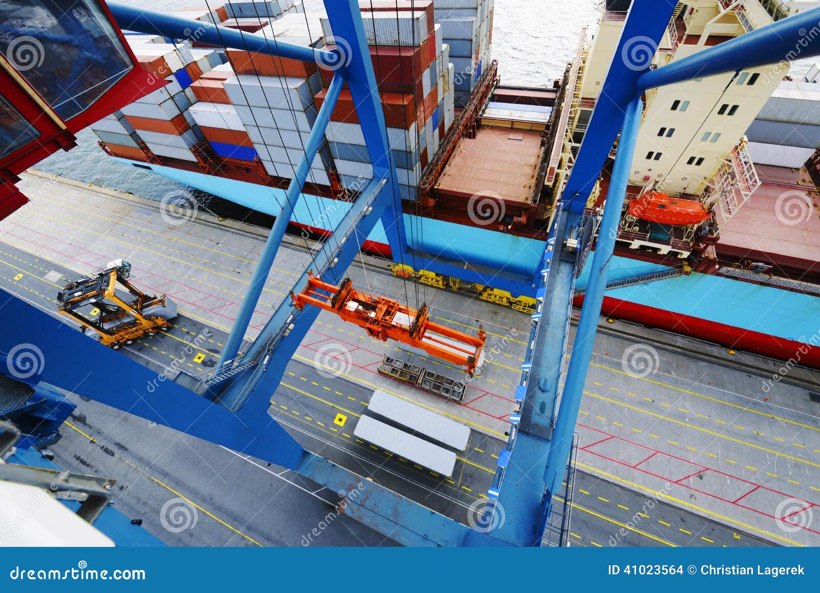 Container crane loading containers onto ship, shot from high above 