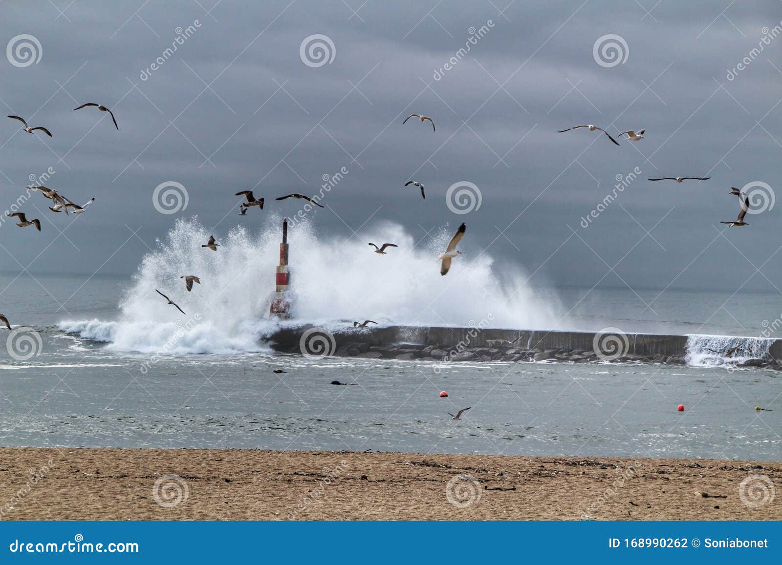 Giant Waves Breaking on the Breakwater and the Lighthouse Stock Photo