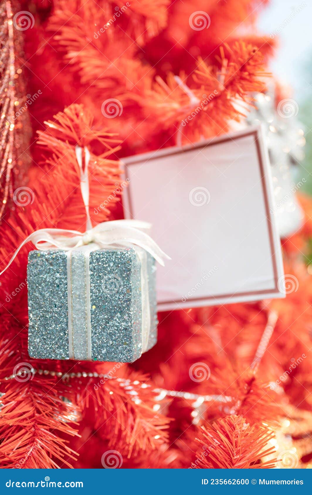 Gift Box with Greeting Card Hanging on Christmas Tree Stock Photo