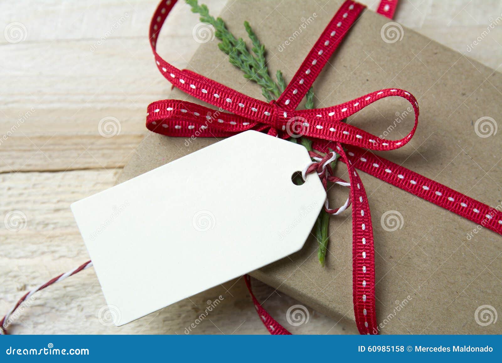 Gift Box, Wrapped In Recycled Paper, Red Bow And Tag On Wood Bac Stock