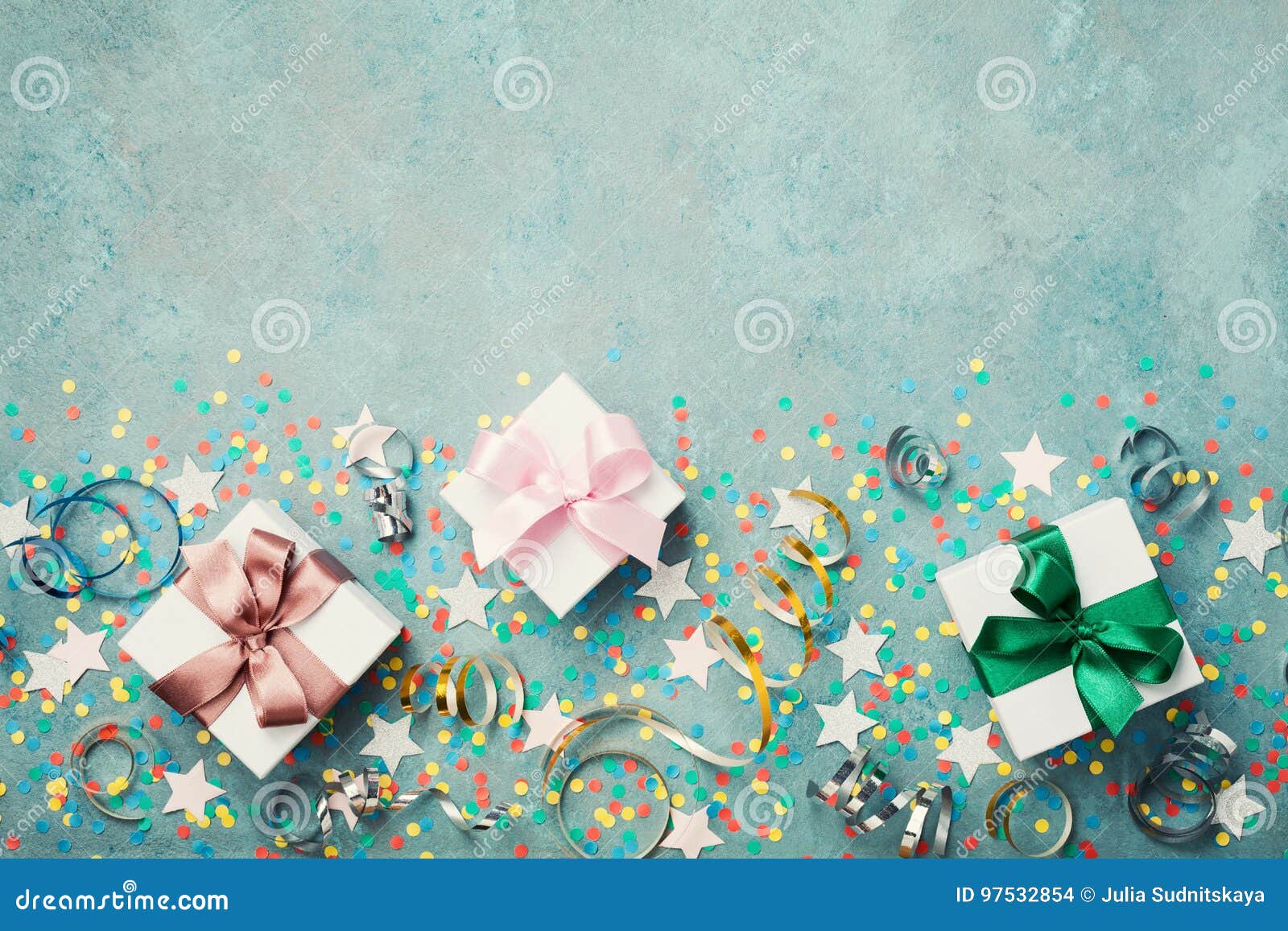 gift or present box decorated colorful confetti, star and streamer on blue vintage table top view. flat lay style. birthday.