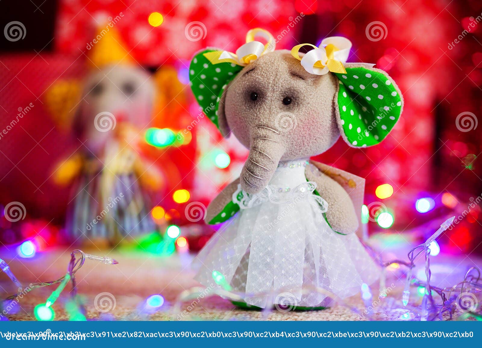 Gift Toy Elephant Standing on Background of Christmas Lights and Boxes