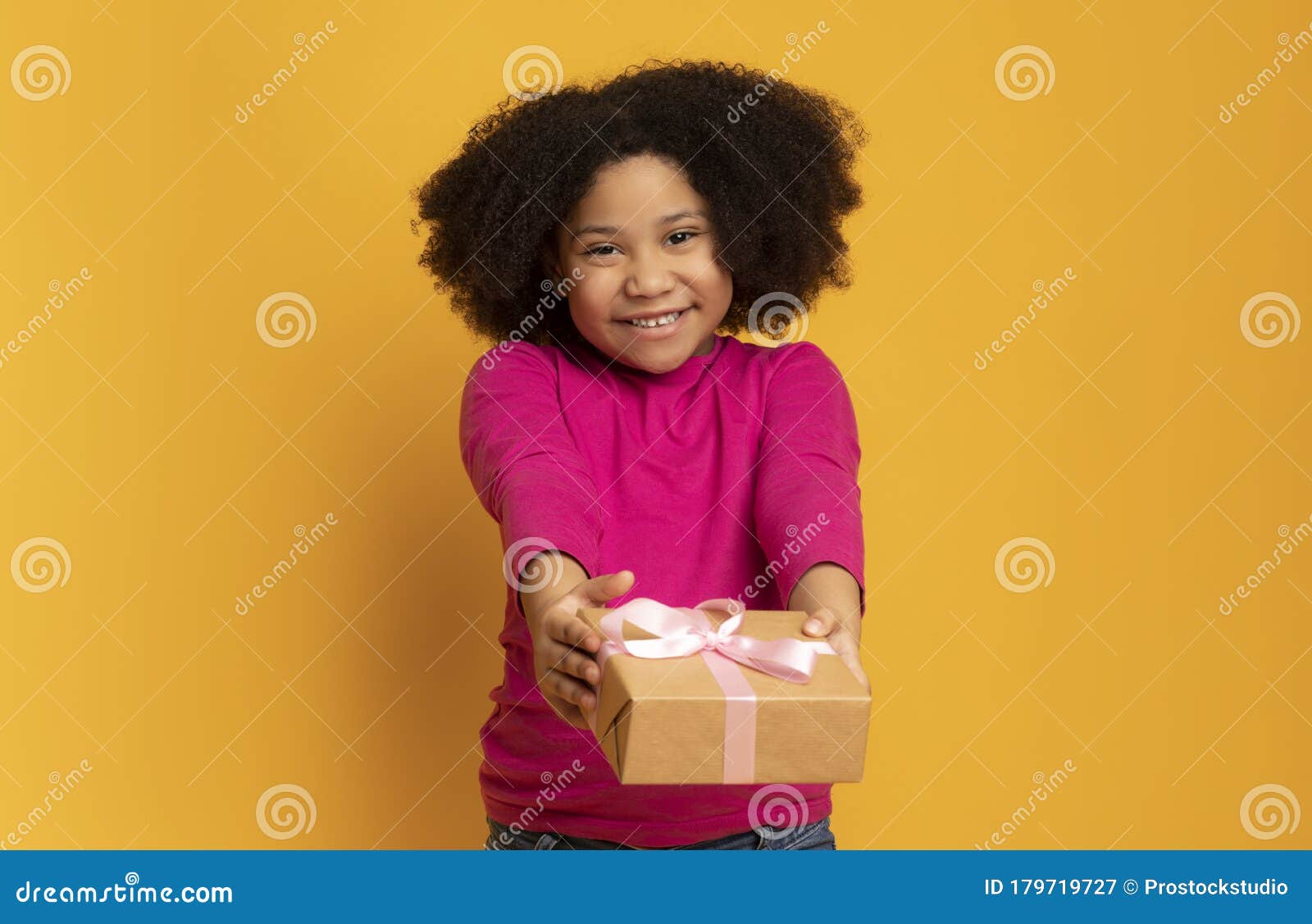 gift for you. adorable black girl giving present box at camera