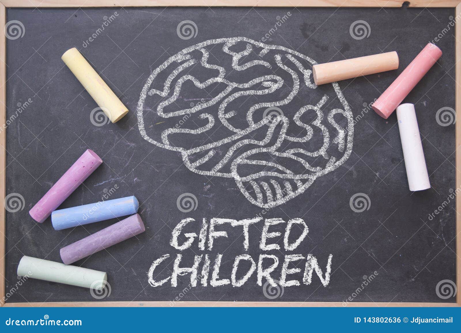 gifted children and education concept written on a blackboard in a classroom. brain drawing and some colored chalk on a chalkboard