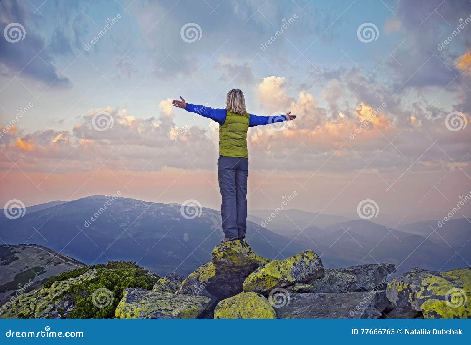 Giovane donna su una pietra con le mani sollevate sulla cima del supporto grande Sivulja, carpatica, Ucraina