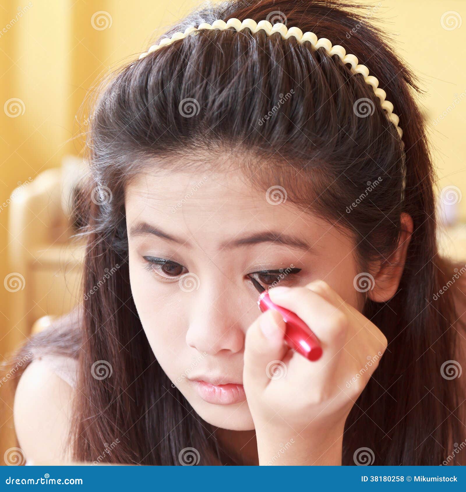 Girl applying eyeliner stock photo. Image of pretty, female 38180258