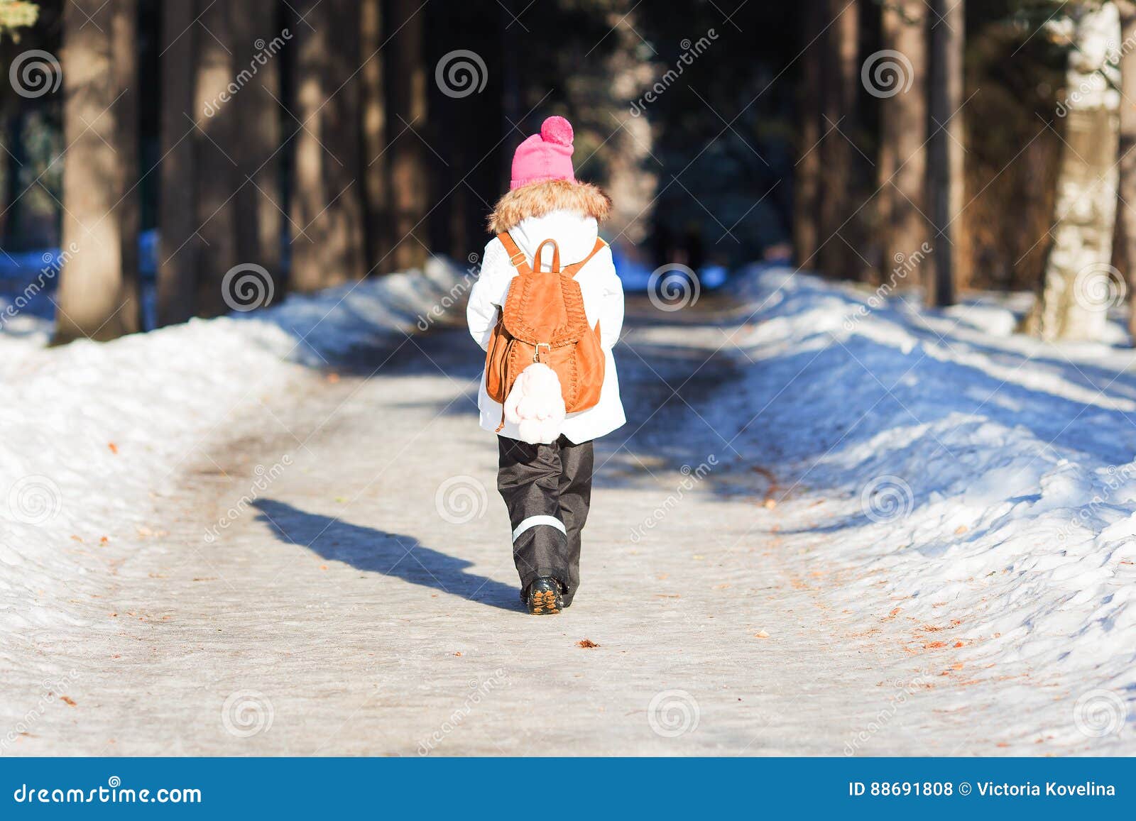 Girl with a Backpack Walks Along the Alley in the Park on a Sunny ...