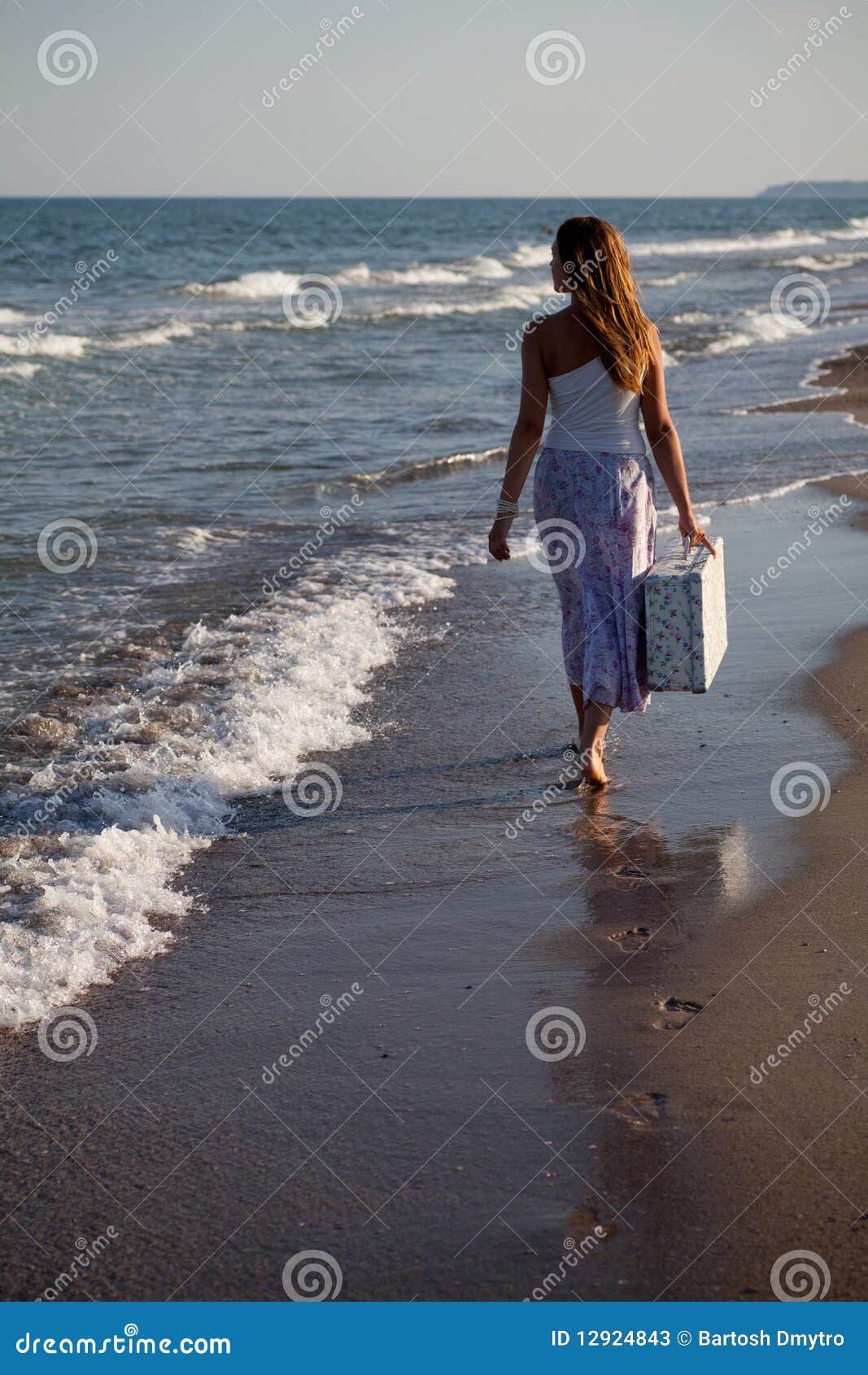 Girl is on the beach. Girl goes to the beach with a suitcase in his hand