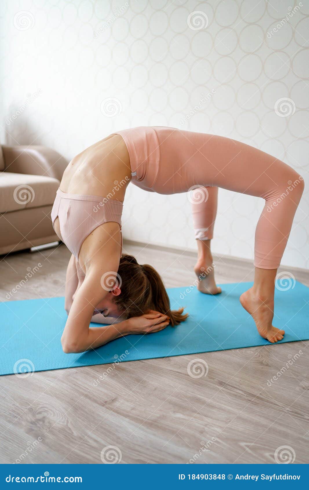 Girl with Beautiful Athletic Body Does Yoga Exercises at Home