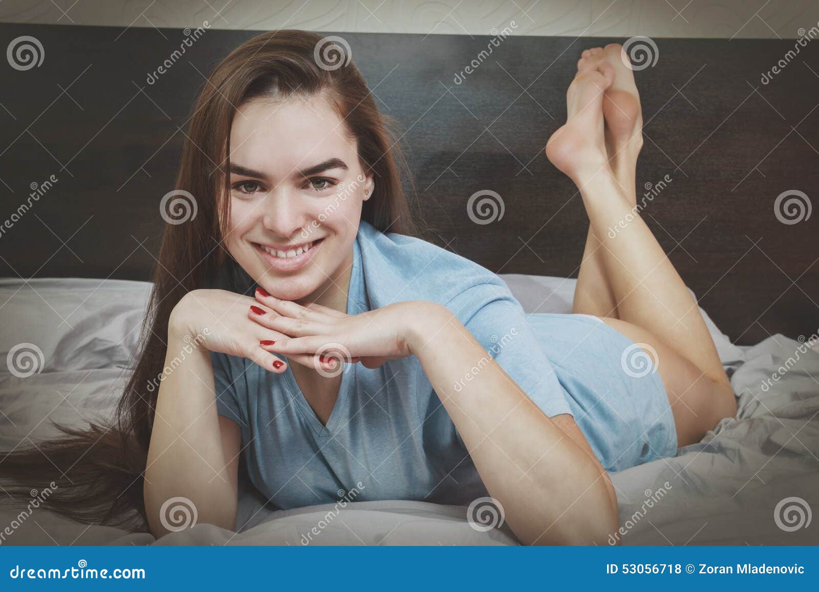 Girl On Bed Seducing Man While Looking At Camera Stock Photo