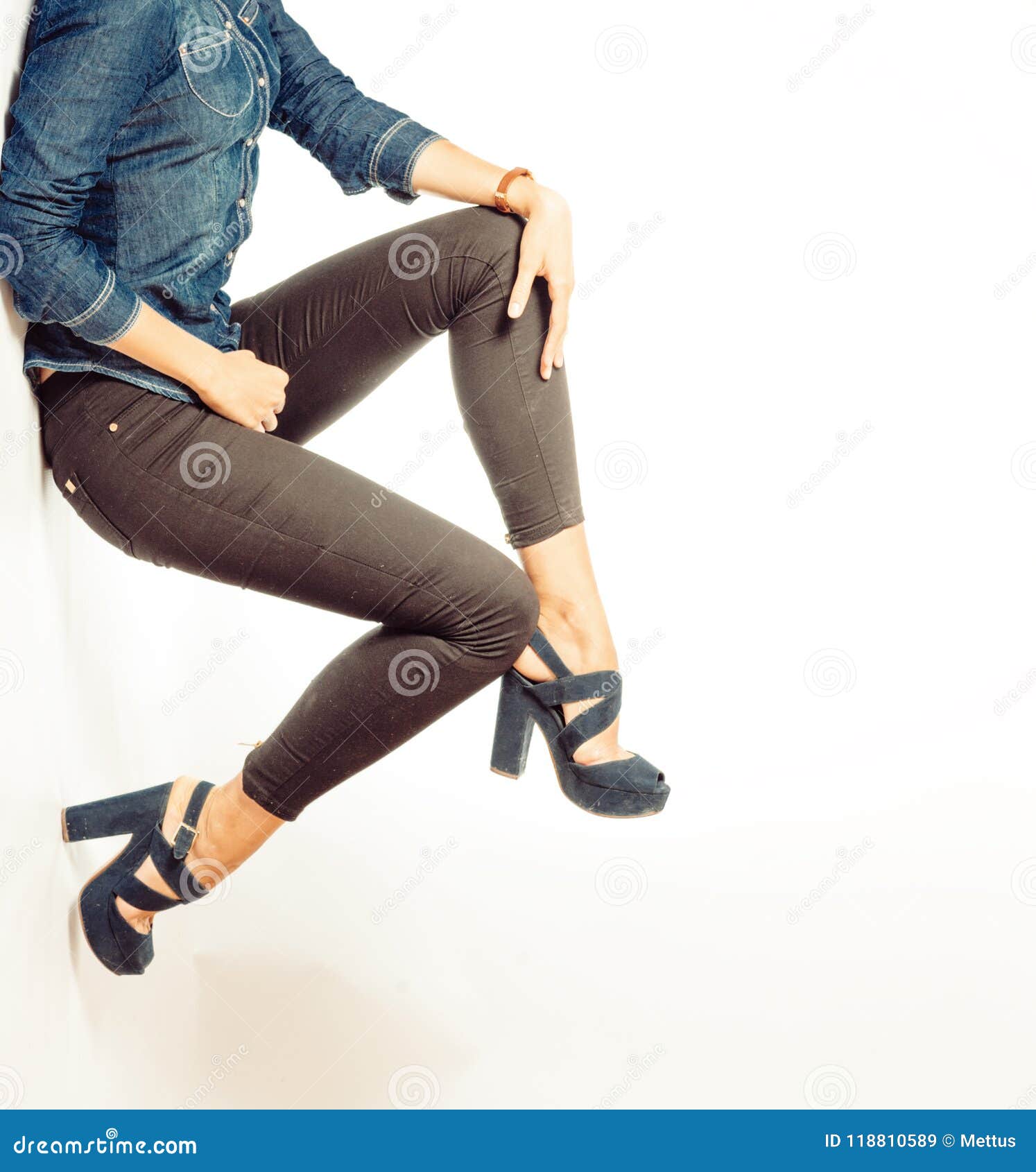 Young woman wearing a blue top, black jeans and high heels posing in front  of a gray wall with stone..., Stock Photo, Picture And Rights Managed  Image. Pic. IBR-2353647 | agefotostock