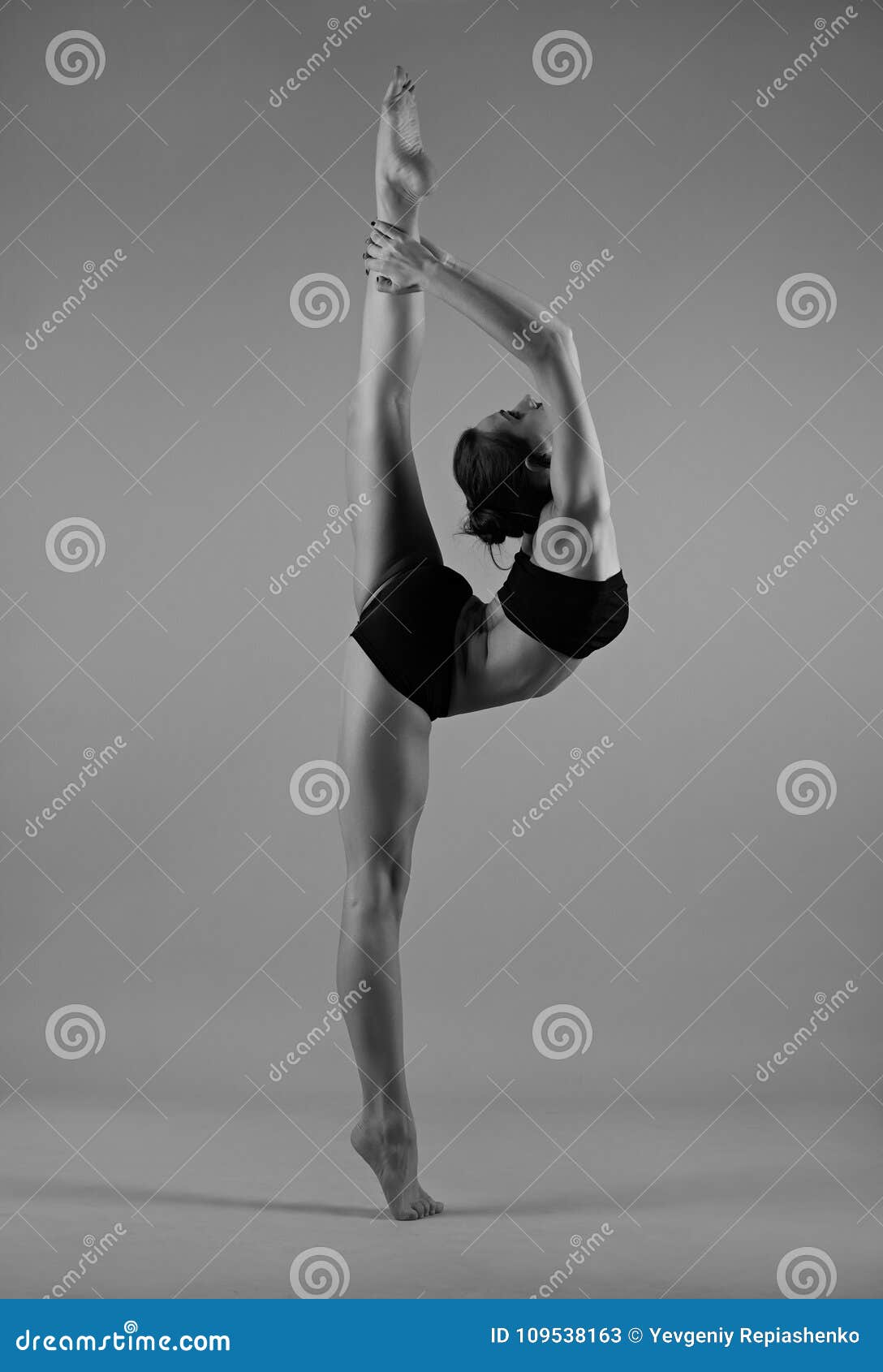 Flexible little girl in red leotard doing gymnastic Stock Photo by licsiren