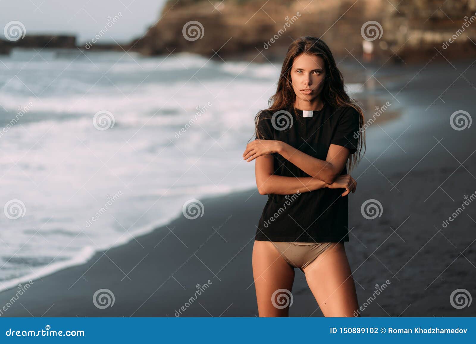 Woman Wearing Bikini Pants And Wet T-shirt Standing On The Beach