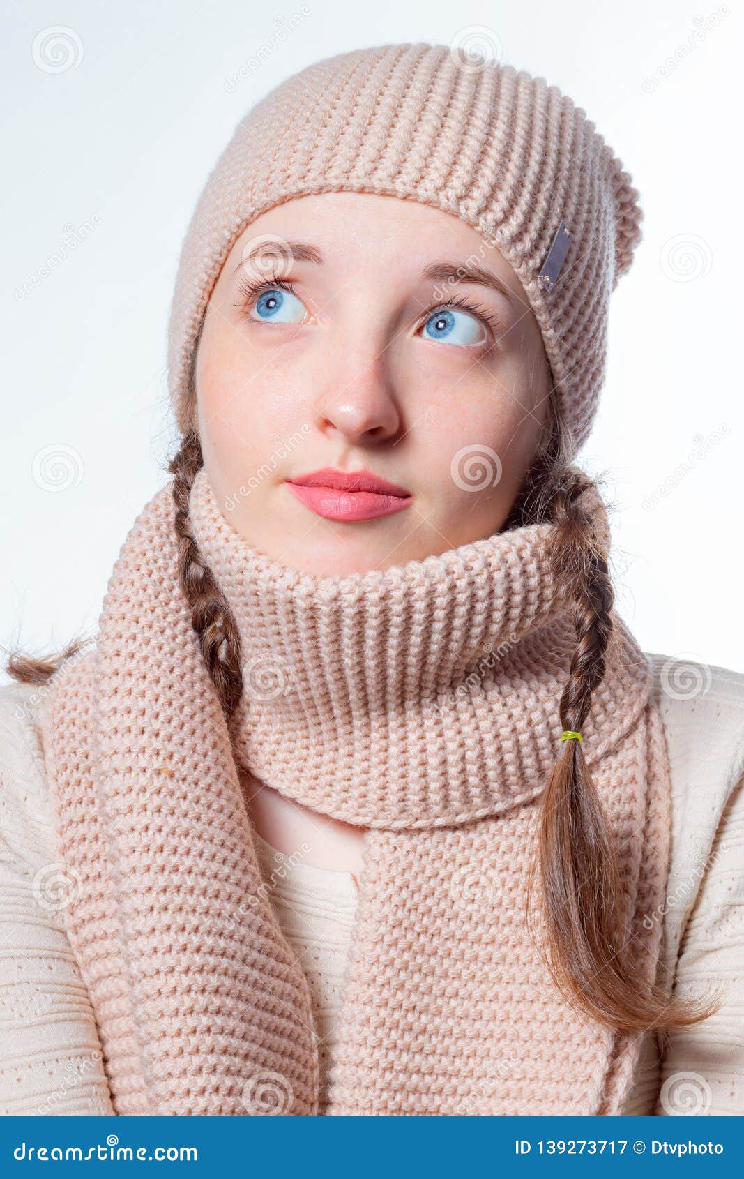 Girl with Blue Eyes and Wicker Braids in a Knitted Hat and Scarf. Light ...