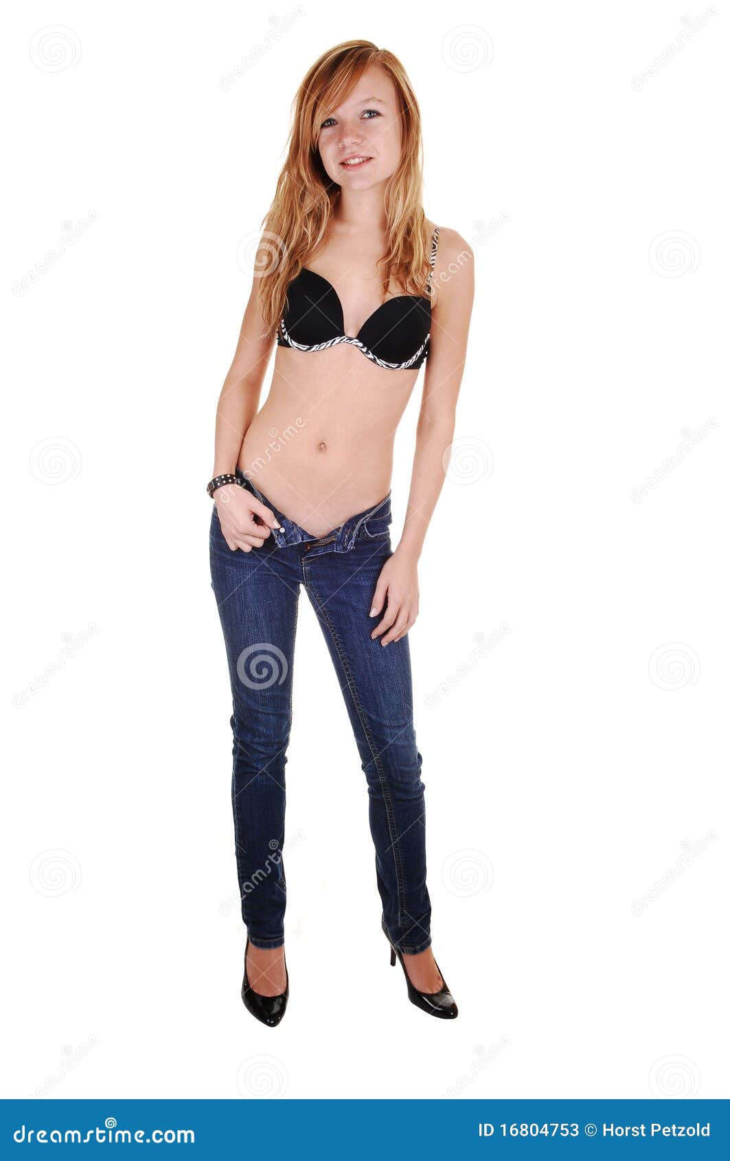 Beautiful sporty lady in red bra and blue jeans against dark background  Stock Photo