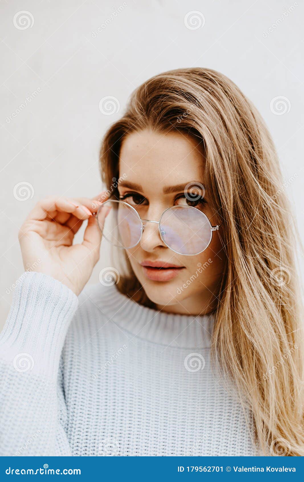 Girl With Brown Eyes With A Strict Look Looks Over Glasses On A White ...