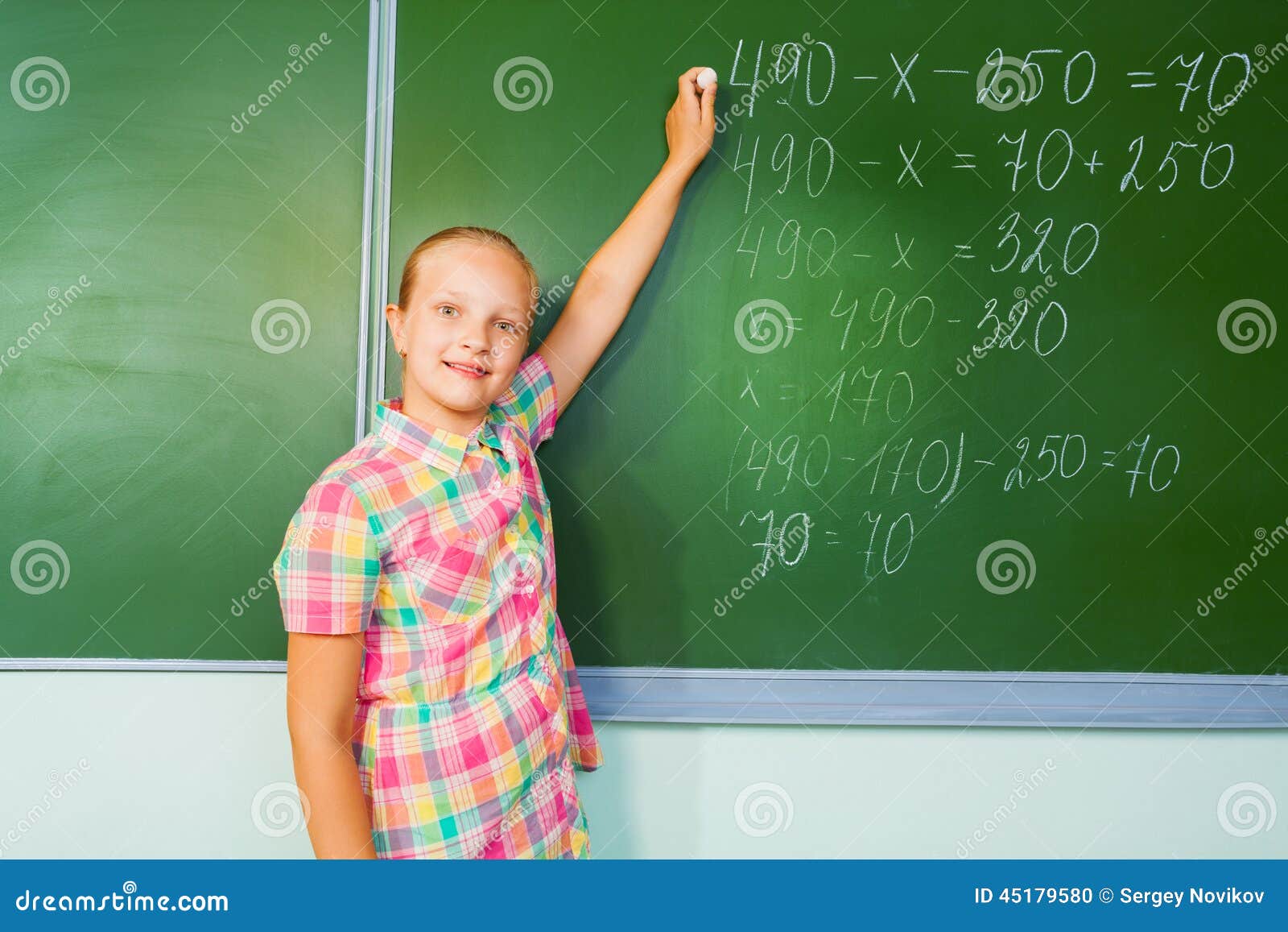 girl chalk writing mathematics equation beautiful her hand looking straight front blackboard 45179580