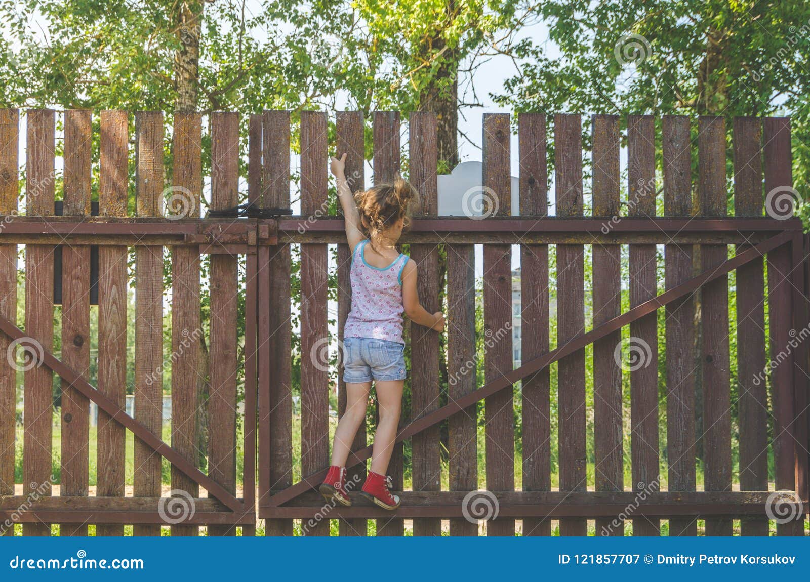 Girl Climbs The Fence On A Summer Day Stock Image Image Of Caucasian