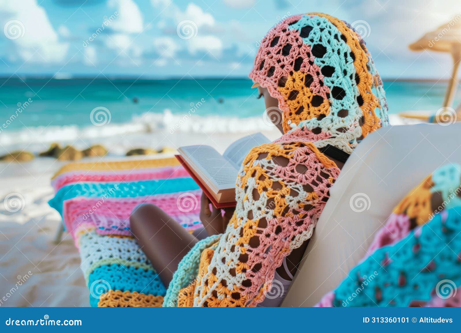 girl in a crochet coverup reading a book on a beach lounger