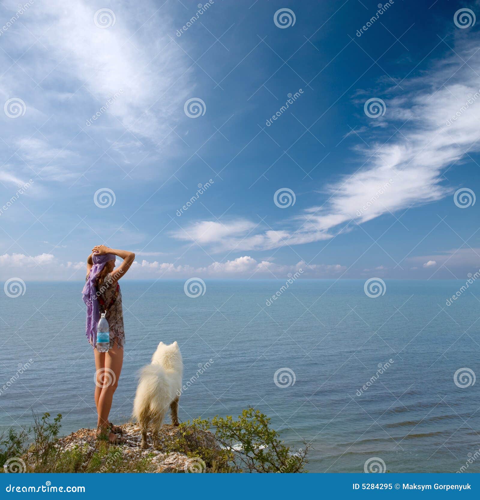 girl and dog standing on precipice