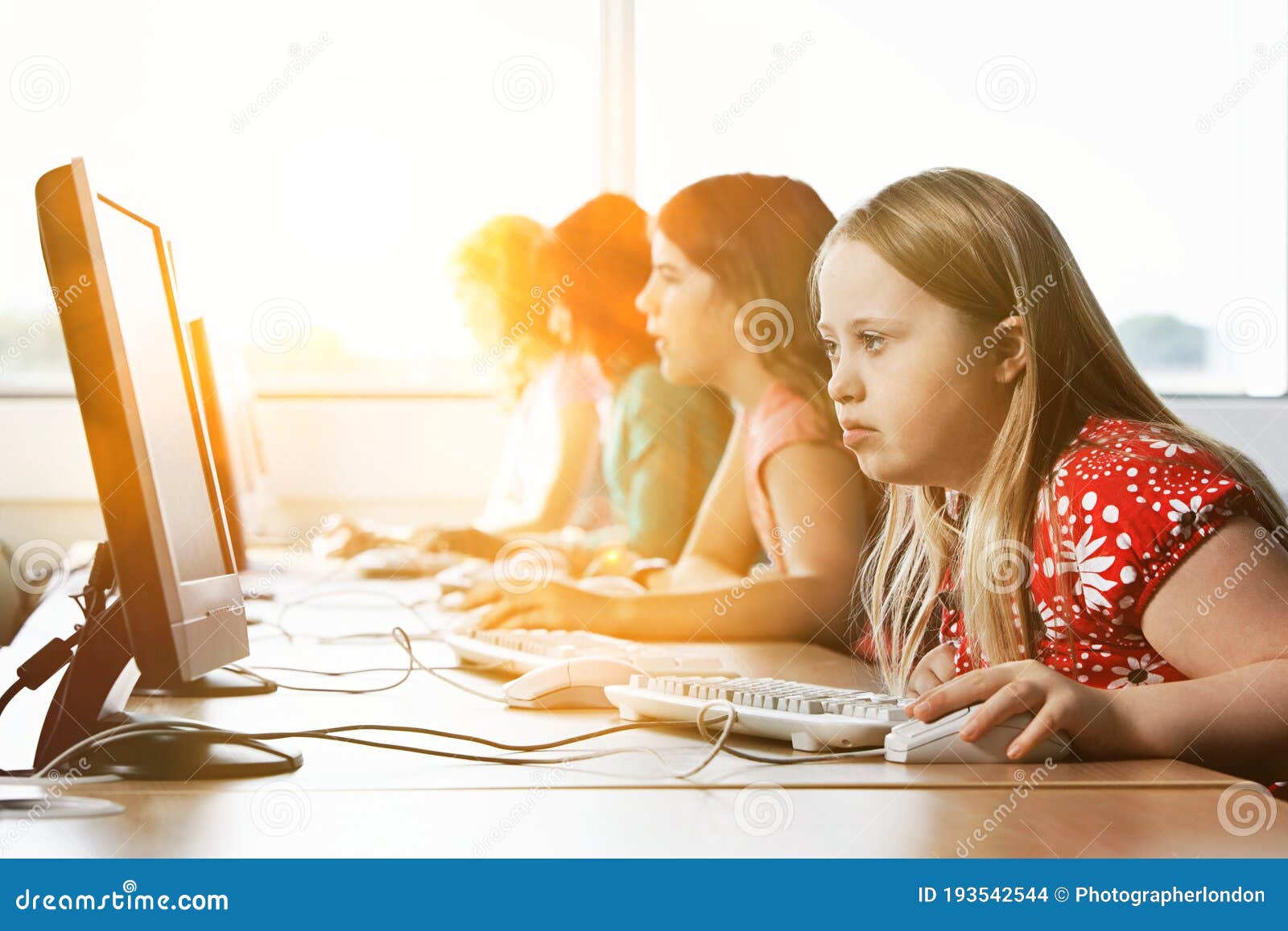 girl with down syndrome using computer at school