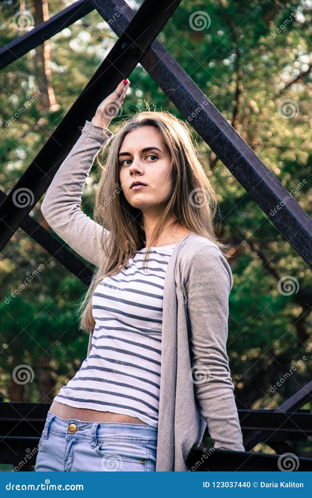 The Girl is Dressed in a White Sweater with Black Strips and in ...